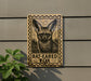 A wooden sign with a bat-eared fox illustration is mounted on a wall, with a plant to the left.