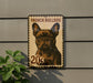 a French Bulldog, which is a brown dog with a distinctive appearance. The dog is depicted in a stamp-like design, with the text "French Bulldog" and "20¢" visible. The dog is shown in profile, with its head turned to the left. The background of the image is a gray wall, and there is a plant visible on the left side of the frame.