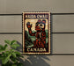 A metal sign with a stylized illustration of a bear and the text "HAIDA GWAI CANADA" is mounted on a wall.