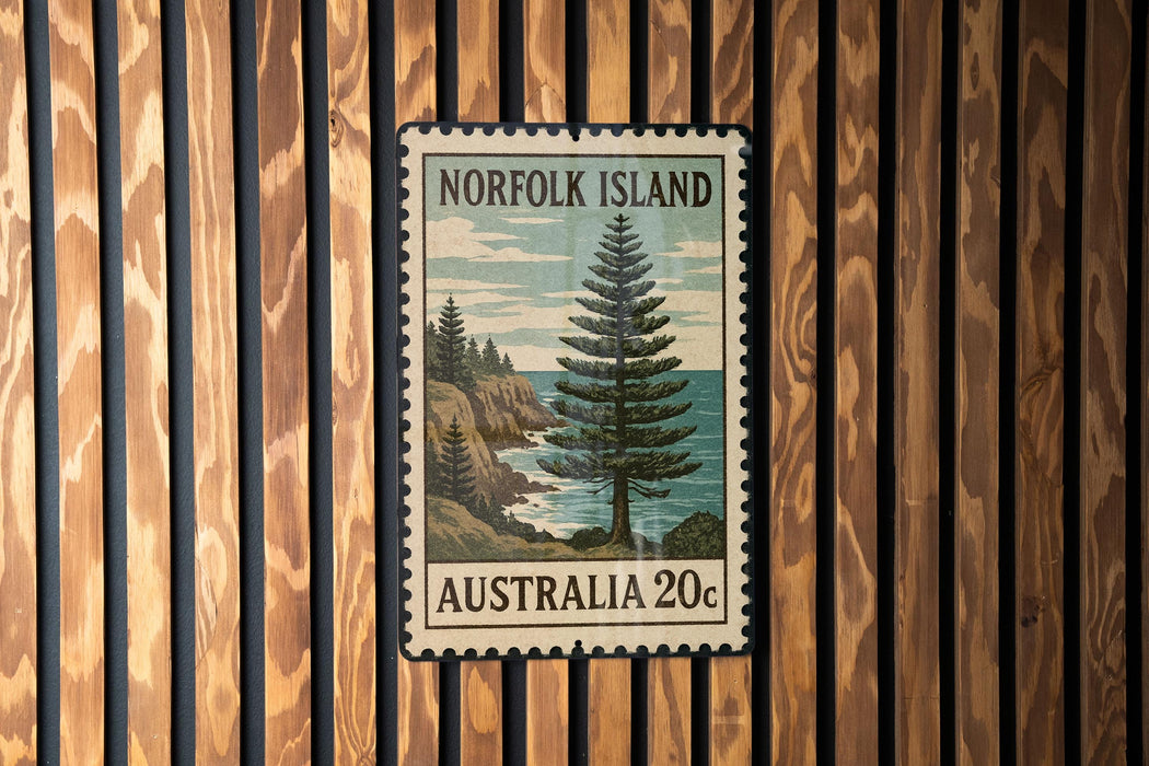 A vintage postage stamp from Norfolk Island, Australia, featuring a pine tree and a coastal landscape.