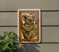 a koala bear, which is a type of primate, depicted in a decorative frame on a wall.