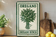 a sign for "Oregano Bunch" with a green and white design, placed on a wooden shelf next to a potted plant and a cutting board.
