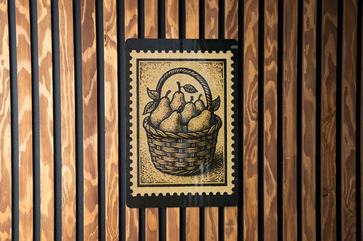 A framed illustration of a basket filled with pears is displayed on a wooden wall.