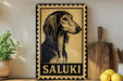 a framed illustration of a Saluki dog, with the word "SALUKI" written below it. The framed picture is displayed on a shelf next to a wooden cutting board and a potted plant.