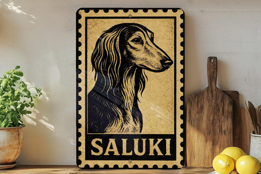 a framed illustration of a Saluki dog, with the word "SALUKI" written below it. The framed picture is displayed on a shelf next to a wooden cutting board and a potted plant.