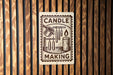 a sign that reads "CANDLE MAKING" with illustrations of a candle and other related items.