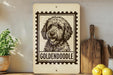 A wooden sign with a black and white illustration of a golden retriever dog, labeled "GOLDENDOLE", is displayed on a shelf next to a potted plant and a wooden cutting board.