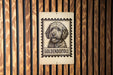 A sign featuring a dog's head in a stamp-like design, with the word "GOLDEN doodle" written below it.