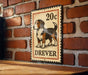 A metal sign with a dog illustration and the text "DRIVER" is mounted on a brick wall.