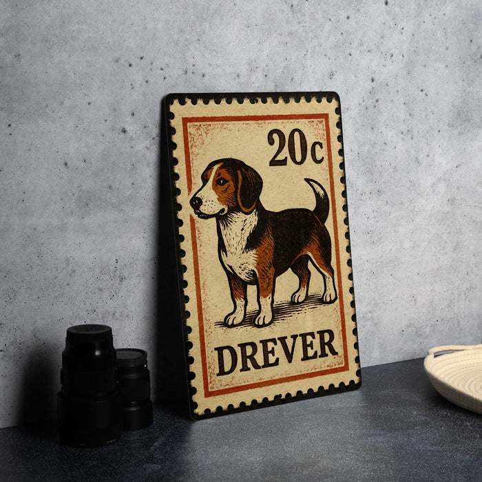 A metal sign featuring a dog illustration and the text "DREVER" is displayed on a table.
