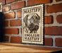 A metal sign with a black and white illustration of a mastiff dog, mounted on a brick wall.