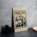 a sign with a rabbit illustration and the text "MINI LOP 20c" on it, placed on a table next to some black camera lenses.