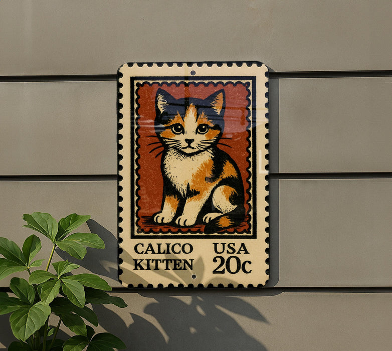 A Calico kitten postage stamp is displayed on a wall, with a plant visible to the left.