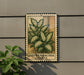 a decorative sign with a plant illustration on it, mounted on a wall.