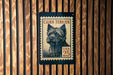 A Cairn Terrier dog stamp is displayed on a wooden wall.