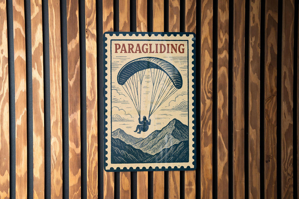 A vintage-style poster of a person paragliding is displayed on a wooden wall.