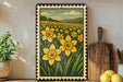 a framed painting of a field of yellow daffodils, with a wooden cutting board and a potted plant visible in the foreground.
