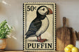 A vintage-style metal sign featuring a puffin, with a postage stamp price of 50 cents, is displayed on a wooden surface next to a wooden cutting board and some lemons.