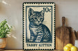 A metal sign featuring a kitten illustration, with the text "Tabby Kitten" below the image.