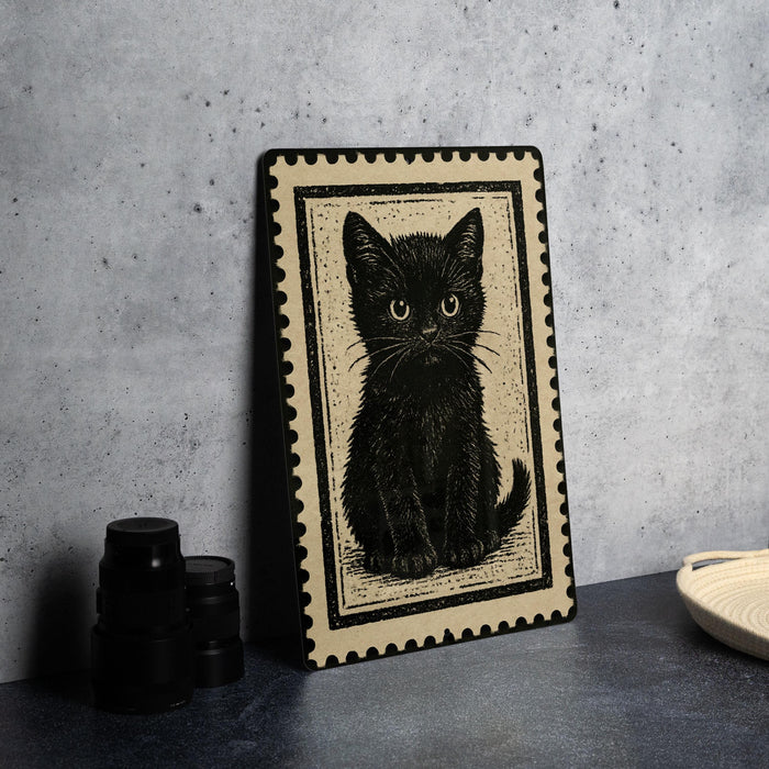 A framed black and white illustration of a cat is displayed on a gray wall, accompanied by a stack of black camera lenses and a woven basket.