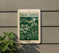 a sign for a " Shade Garden" with a green and white design depicting various plants and foliage.