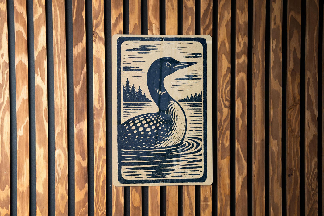 A wooden wall with a framed illustration of a loon, a type of bird, depicted in a black and white style.