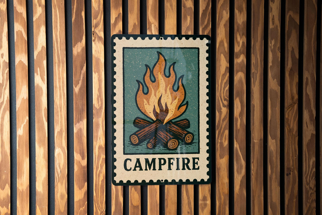 A metal sign with a campfire illustration is mounted on a wooden wall.