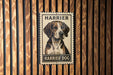 A metal sign with a picture of a dog, labeled "Harrier Dog", is mounted on a wooden wall.