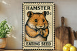 A metal sign with a hamster eating a seed, placed on a wooden surface next to a wooden cutting board and some lemons.