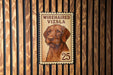A metal stamp featuring a dog's portrait on a wooden background.