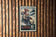 A vintage-style postage stamp depicting a young boy riding a sled, with the text "Sledding 6c" and a snowy landscape in the background.