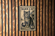A metal stamp featuring a cat on a wooden background.