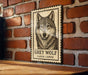 A framed image of a grey wolf is mounted on a brick wall.