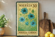A vintage-style metal sign with a floral design, featuring blue flowers, is displayed on a shelf next to a wooden cutting board and some potted plants.