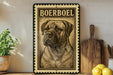 A framed illustration of a Boerboel dog is displayed on a shelf, accompanied by a wooden cutting board, a potted plant, and some lemons.