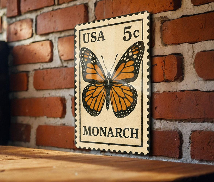 A US 5c postage stamp featuring a detailed illustration of a monarch butterfly is displayed on a brick wall.