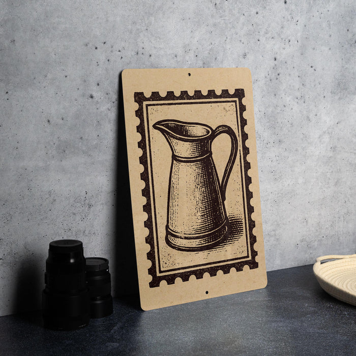 a wooden sign with a black and white illustration of a pitcher, placed on a gray countertop next to some black camera lenses.