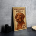 A metal sign featuring a dog illustration and the text "WREHAIRED VIZSLA 25" is displayed on a table.