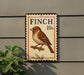 a sign with a bird illustration, mounted on a wall.