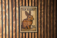 A tan rabbit stamp is displayed on a wooden wall.