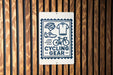 a sign that reads "CYCLING GEAR" with various cycling-related icons and text.