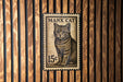 A metal stamp featuring a cat on a wooden background.