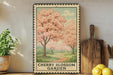 A framed illustration of cherry blossoms in full bloom, with a path leading through a garden, is displayed on a shelf next to a wooden cutting board and a potted plant.