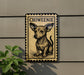 a sign with a chihuahua illustration on it, mounted on a wall.