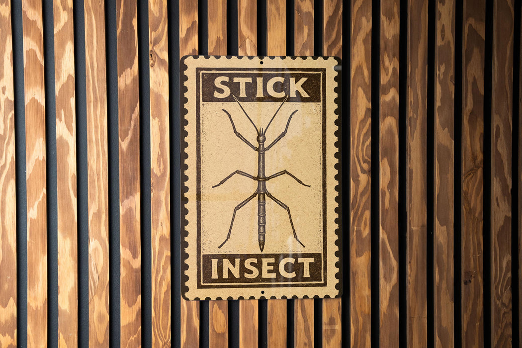 a sign with the word "STICK" and "INsect" printed on it, mounted on a wooden wall.