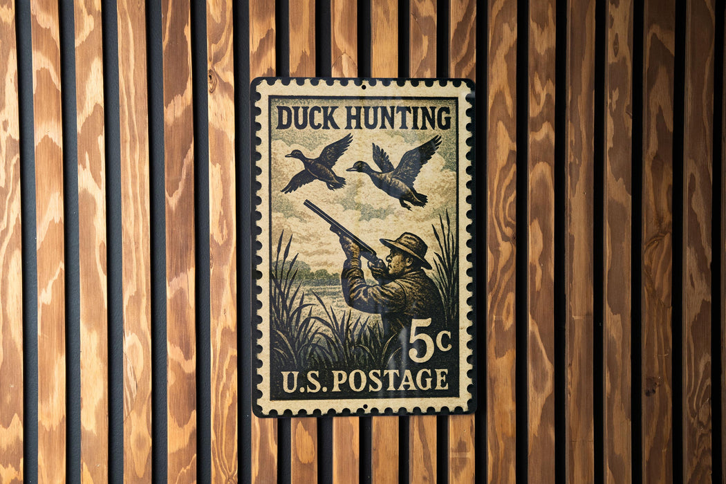 A U.S. postage stamp featuring a man aiming a rifle at ducks in a wooded area.