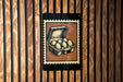 a wooden wall with a framed illustration of a carton of eggs.