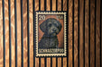 A 20 US postage stamp featuring a black Schnauzer dog.