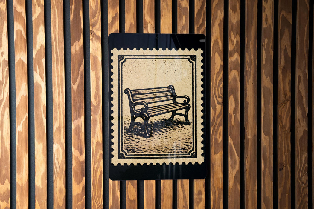 A black and white illustration of a bench is displayed on a wooden wall, framed by vertical slats.