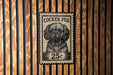 A black and white postage stamp featuring a Cocker Puff dog, with the text "COCKER PUG" and "25c" printed on it.